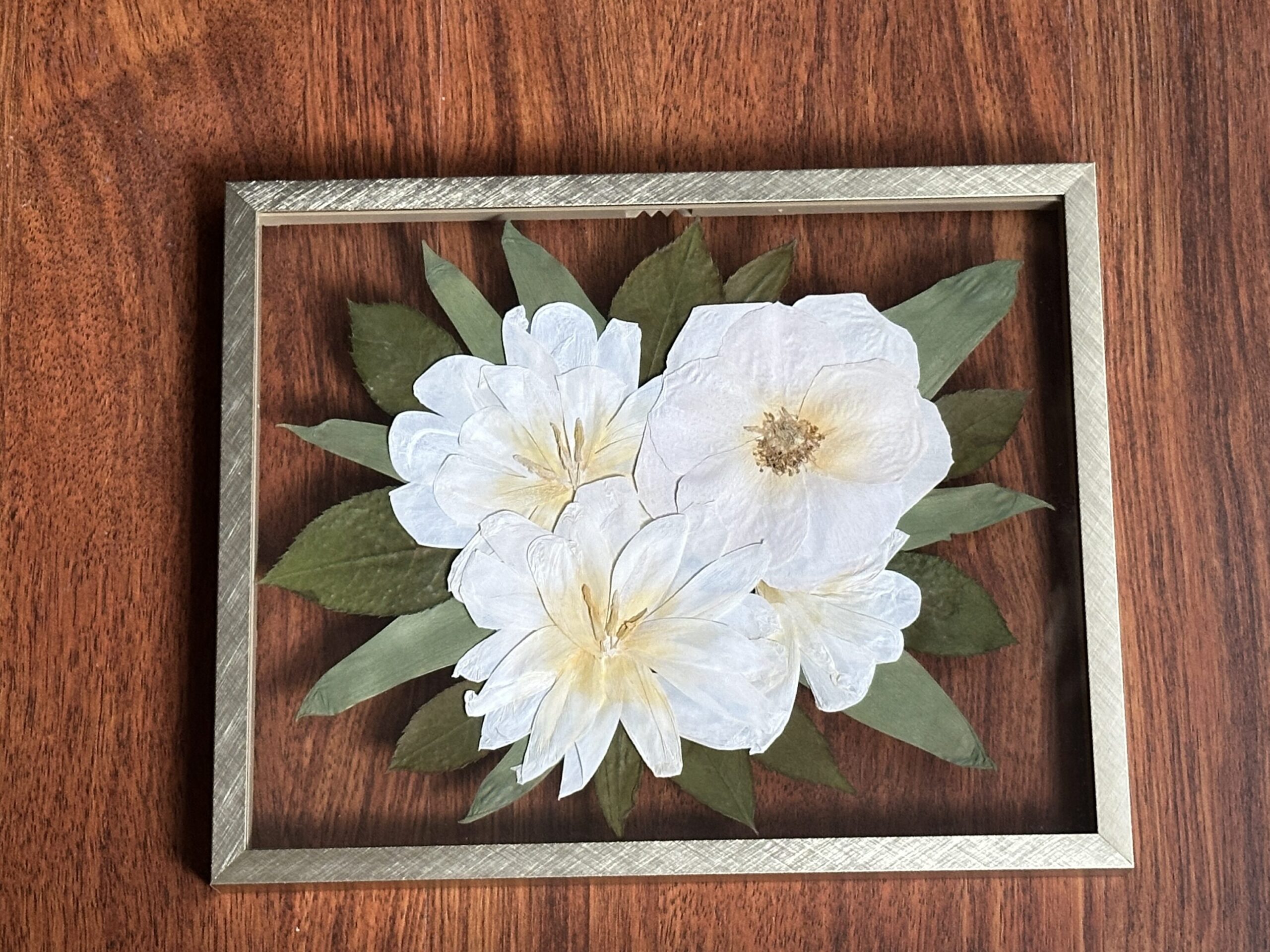 pressed flower frame featuring white color corrected tulips and roses with greenery